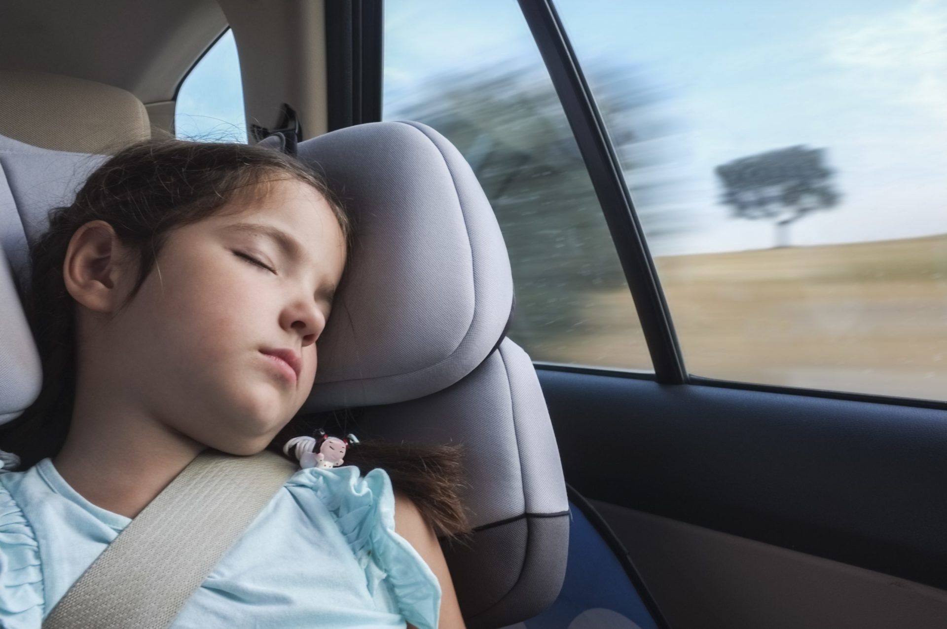child sleeping in car seat on roadtrip