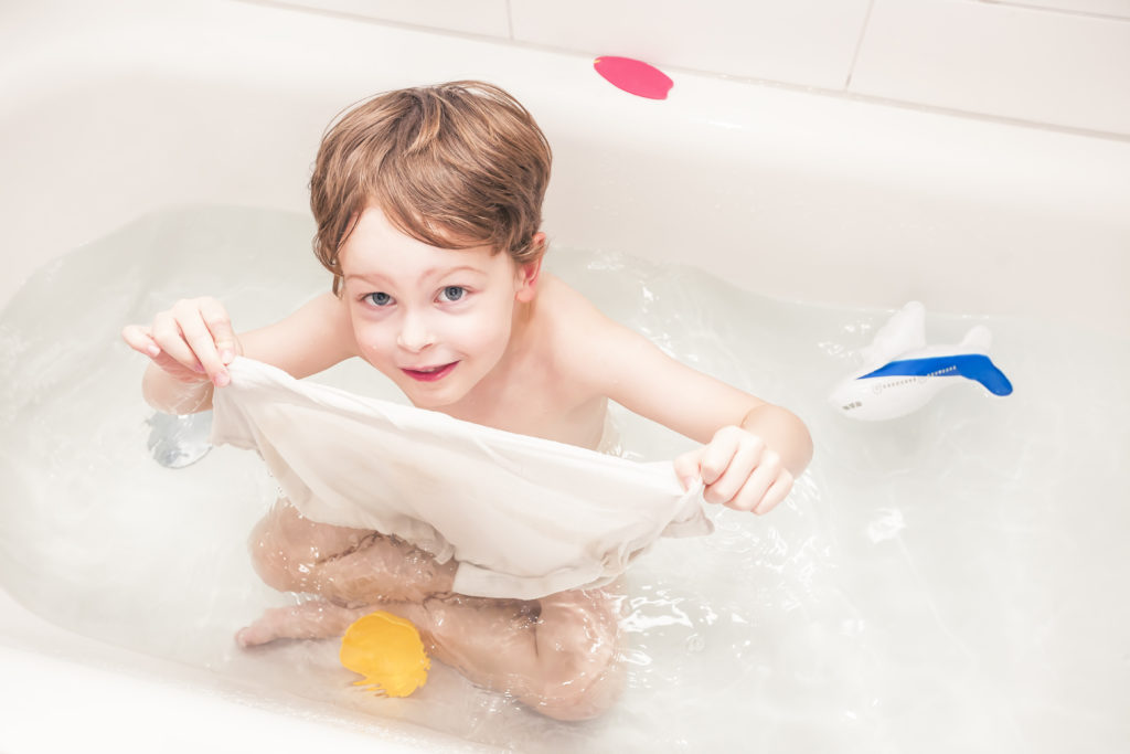 happy young boy playing in bathtub