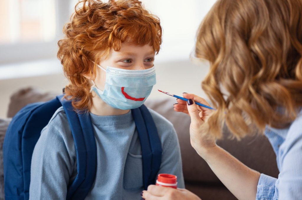 painting a facemask on young child