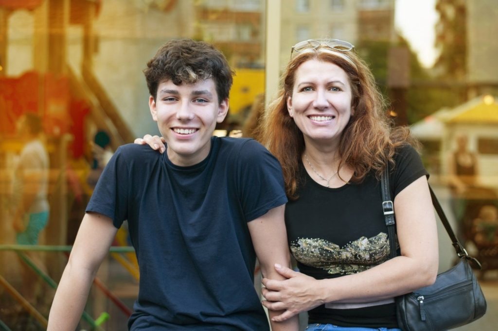 mom sitting with son on a bench